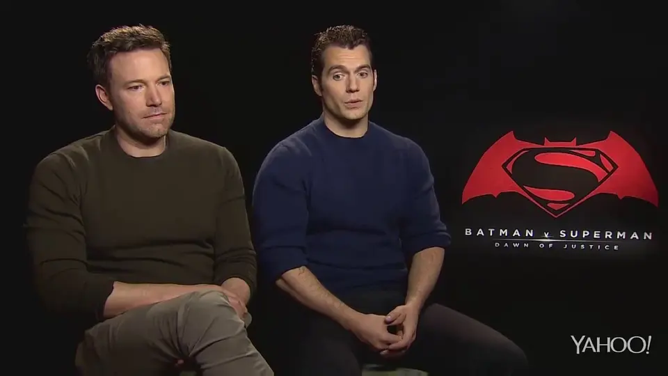 A dejected Ben Affleck seated beside Henry Cavill during the Batman v Superman interview