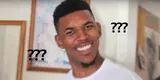Grinning man in a white T-shirt turning to camera with a baffled squint, black "???" marks floating on either side