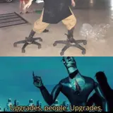 Photo of legs standing on office-chair wheel bases above a still of a blue robot captioned "Upgrades, people. Upgrades."