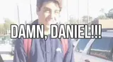 Smiling teenage boy in a navy jacket with a red backpack in a school parking lot, captioned "Damn, Daniel!!!"