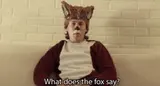 A man in a fox costume on a couch under the subtitle "What does the fox say?"