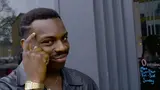 A man tapping his temple with a knowing smirk