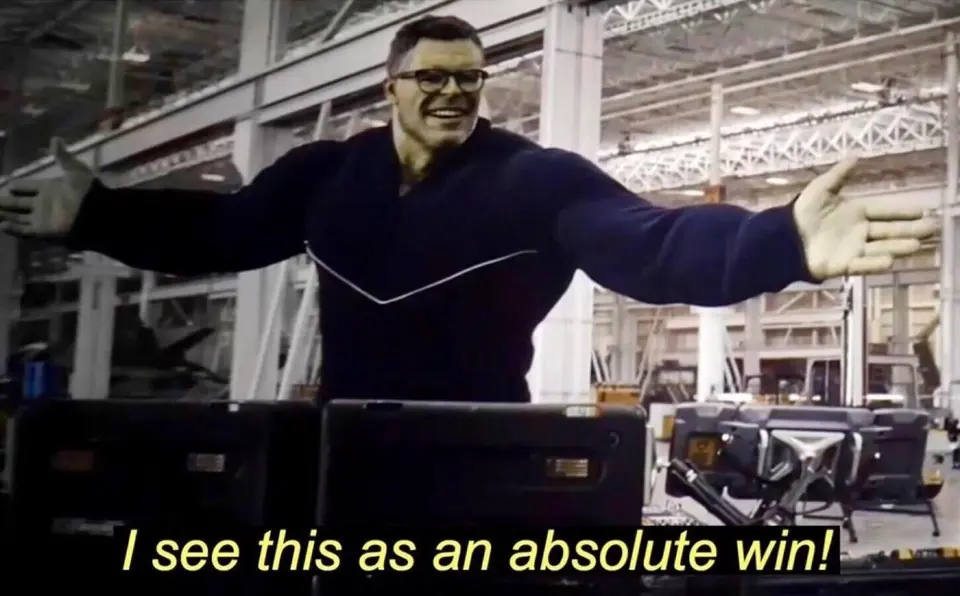 Green-skinned man in glasses and a navy sweater spreading his arms wide, subtitled "I see this as an absolute win!"