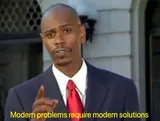 Man in a navy suit and red tie pointing while speaking outdoors, yellow caption "Modern problems require modern solutions"