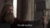 Long-haired bearded man in a red cape grinning as he holds a war hammer aloft, subtitled "I'm still worthy!"