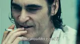 Film still of a smirking man with slicked dark hair holding a cigarette to his lips, subtitled "You wouldn't get it"